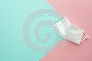 White medical mask. Sky blue and pink background. photo