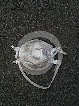 White medical mask thrown on the ground dirtied Face mask protection against pollution, virus, flu and corona virus covid-19. photo