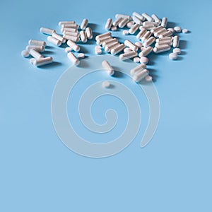 White medical pills on blue background.