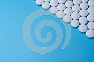 White medical pills on a blue background in the upper right corner.