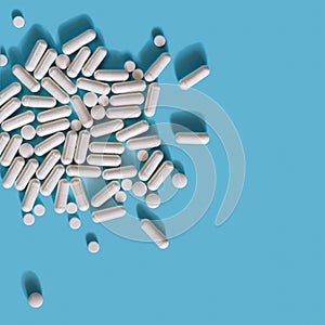 White medical pills on blue background.