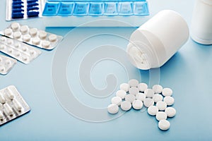 White medical pills and tablets spilling out of a bottle. Mock up bottles with copy space