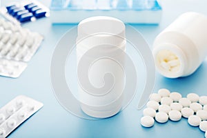 White medical pills and tablets spilling out of a bottle. Mock up bottles with copy space