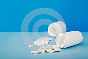 White medical pills and tablets spilling out of a bottle. Mock up bottles with copy space