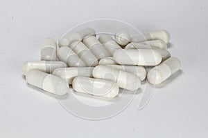 White medicine capsules, pills, tablets on white background