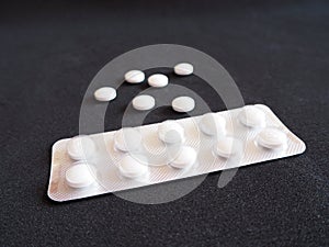 White medicine pills on a black background, modern medicine used to prevent and treat diseases with copy space photo