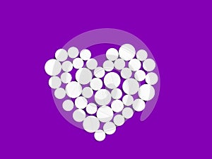 White medicine pills in the shape of a heart on a Violet background top view with copy space.