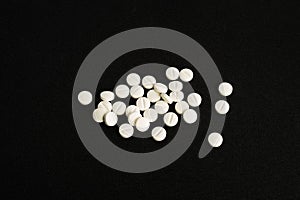 White medicine tablets isolated on black background