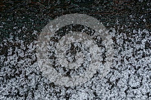 White melting snow on a black wooden board