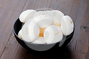 White meringues on a black plate on a wooden background.