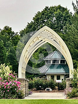 White metal arch with stone and concrete bases in garden