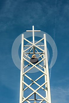 White Metal Bell Tower Against a Blue Sky