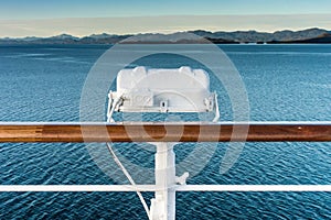 White metal exterior light fixture on railing of cruise ship, Alaska Inside Passage route.