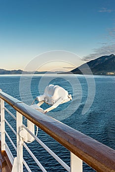 White metal exterior light fixture on railing of cruise ship, Alaska Inside Passage route.