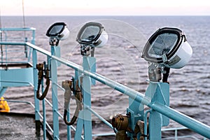 White metal exterior light fixture on railing of cruise ship, Alaska Inside Passage route.