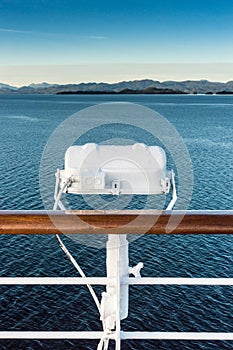 White metal exterior light fixture on railing of cruise ship, Alaska Inside Passage route.