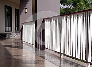 White metal fence on peaceful minimal resort hotel corridor way to rooms with shadows and reflections
