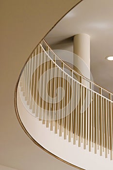 White metal pickets and brass railing on curving balcony with column in background