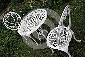The white metal round table and chairs set in the garden.