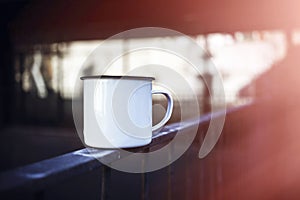 White metal tea cup on the rails. Blurred background. 3d rendering