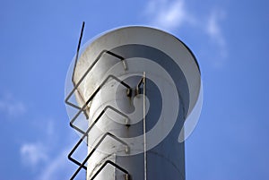 White metallic tube, blue sky background.