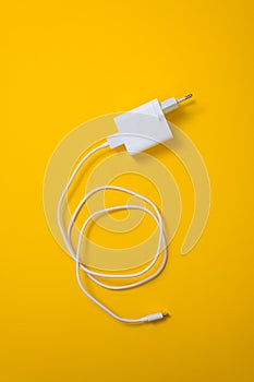 White micro usb type C charger for smartphone on yellow background