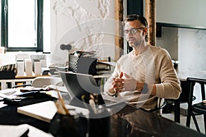 White middle-aged man heaving meeting on a laptop computer in office