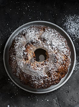 White and milk chocolate banana oatmeal cake on a dark table background, top view. Delicious breakfast, snack, dessert