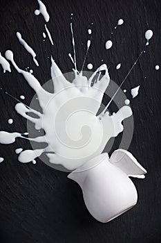 White milk splashes splattered, isolated on black background photo