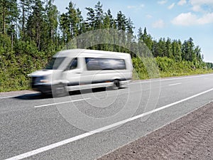 White mini bus on country highway, motion blur