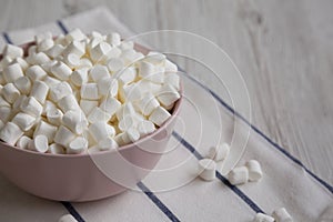 White Mini Marshmallows in a Pink Bowl, side view. Copy space