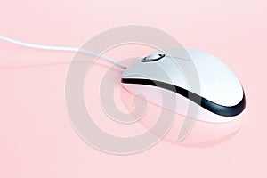 White minimalist computer mouse on pastel pink background