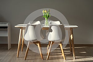 White minimalistic interior with fresh flowers in vase on table