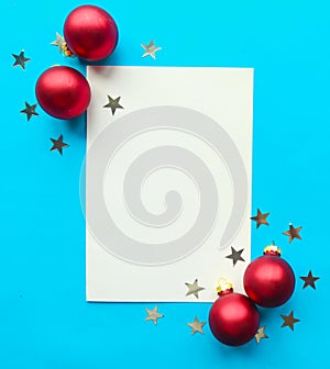 White mockup blank decorative with stars and red baubles on bright blue background.