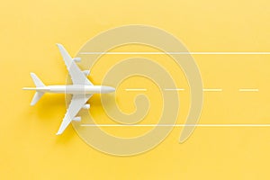 White model plane, airplane on yellow background. Top view, flat lay.