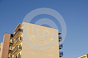 White modern apartments building facade in sunlight on a sunny day with clear blue sky. Vana - Kuuli street. Tallinn