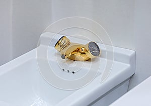 White modern bidet with gold faucet tap in light bathroom. Modern design of toilets