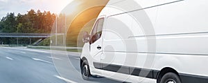 White modern delivery small shipment cargo courier van moving fast on motorway road to city urban suburb. Busines distribution and