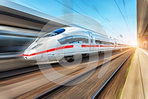 White modern high speed train in motion on railway station