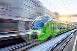 White modern high speed train in motion on railway station at sunset. Train on railroad track with motion blur effect in Europe in