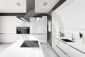 White modern kitchen with steel appliances.