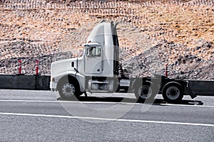 White modern semi truck reefer trailer on green summer highway