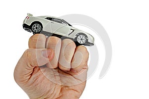 White modern supersport car toy model on a raised man fist, white background photo