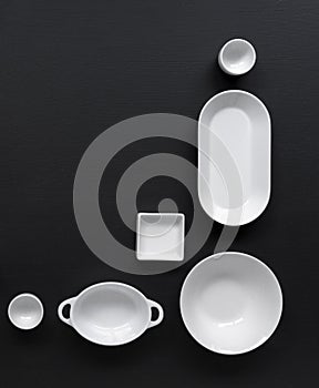 White, modern tableware in various designs on a black background