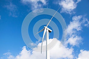 White modern windmill. With blue sky and white clouds. Dutch sky.