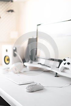 White modern wired gaming mouse in a white comfortable gamer workspace. Close-up of a special device