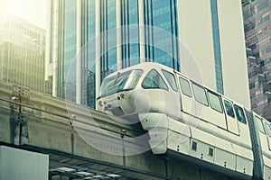 White monorail train against blue sky and modern skyscraper in Kuala Lumpur