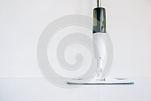 White mop with spray bottle isolated on white background with copy space