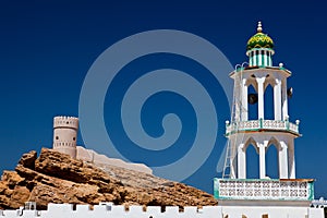 White mosque with minaret against blue sky