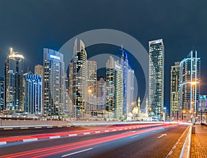 A white mosque near Dubai marina in downtown skyline, United Arab Emirates or UAE. Financial district and business area in smart